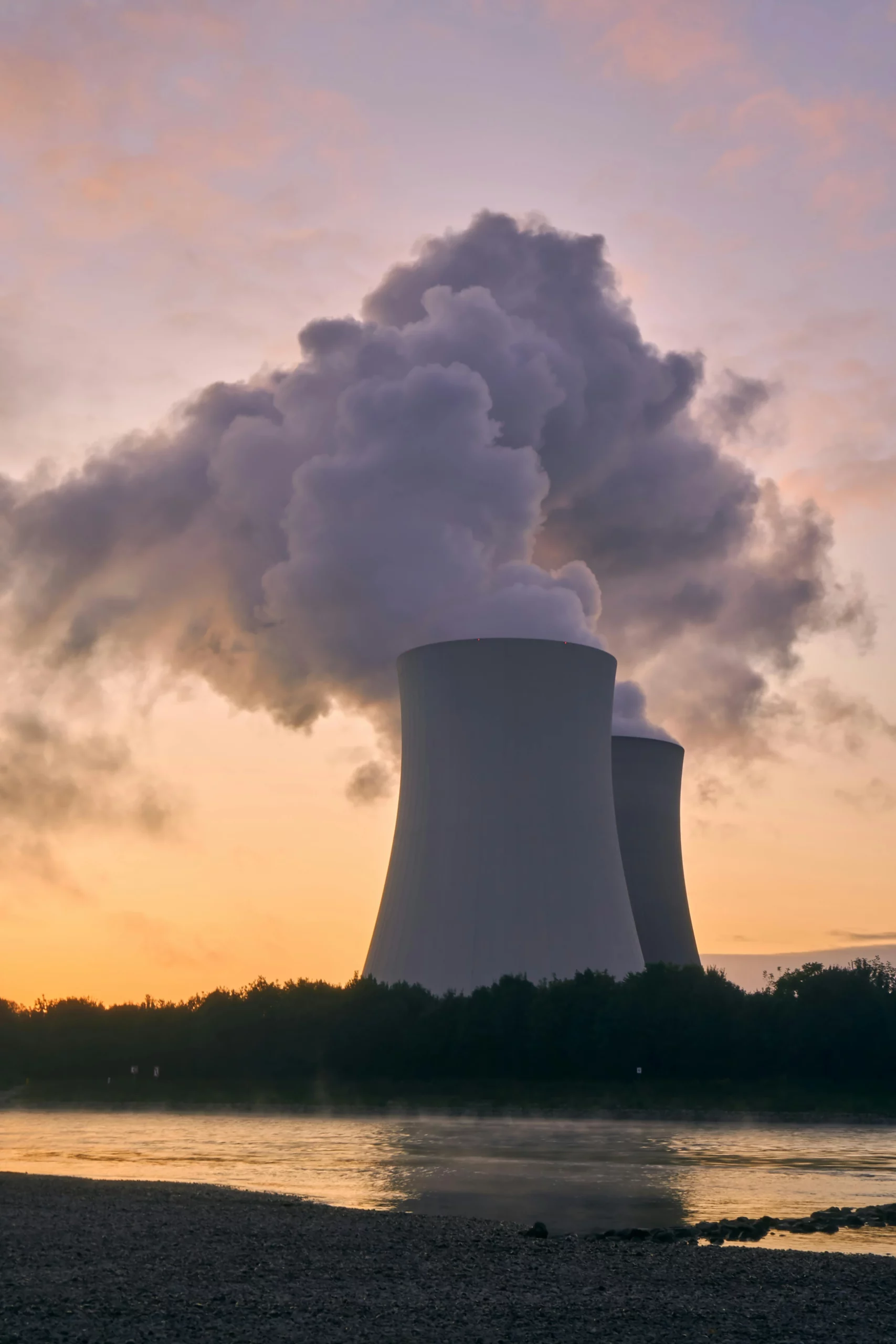 cheminées de refroidissement de centrale nucléaire au bord d'un cours d'eau